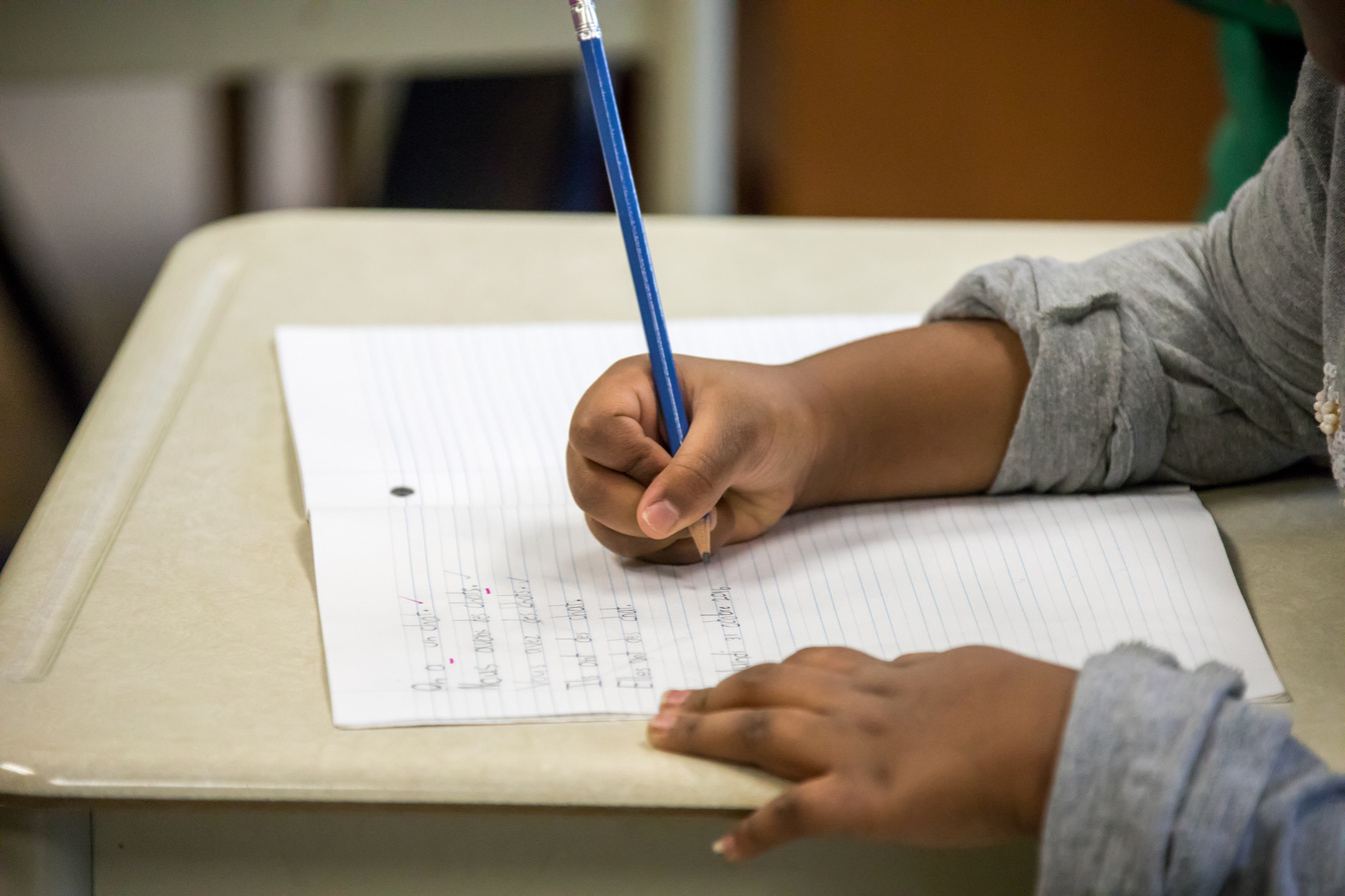 Kids learning and writing in school.
