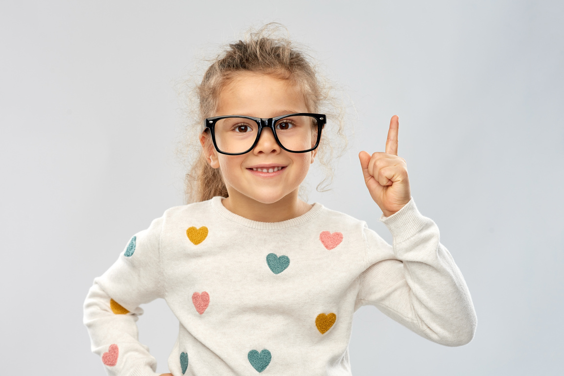 Portrait of a Girl in Glasses Pointing Her Finger Up